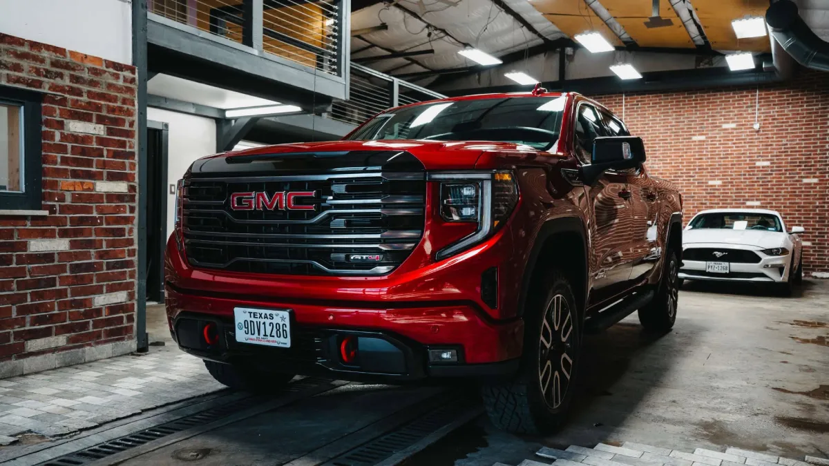 Red GMC truck with shiny paint inside a garage following ceramic coating service.